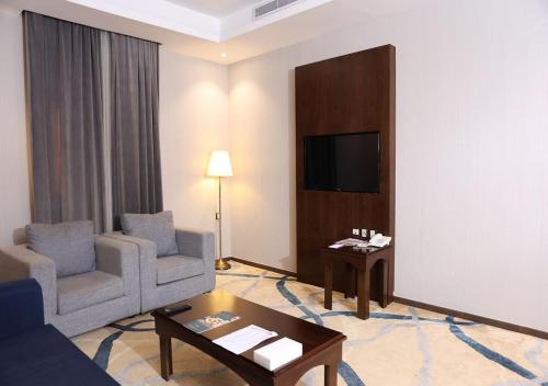 a living room with a couch and chairs and a tv at فندق الفرسان المتحدة شارع حراء - "سانسا" in Jeddah