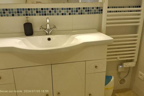 La salle de bains est pourvue d'un lavabo blanc et d'un téléphone noir. dans l'établissement Maison de village chez corinne, à Besse-sur-Issole