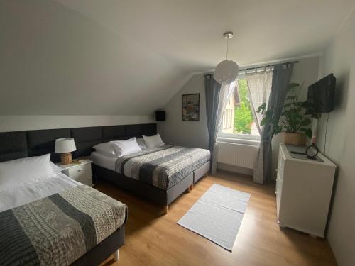 een slaapkamer met twee bedden en een raam bij Apartament w Domu Wypoczynkowym Zacisze in Stegna