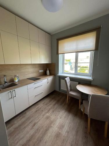 a kitchen with a table and a table and a window at Apartment AMBER in Brocēni