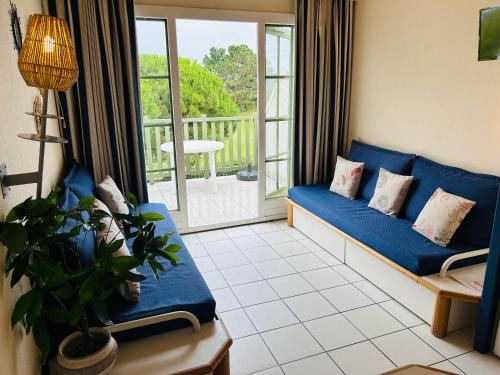 un salon avec un canapé bleu et un balcon dans l'établissement 