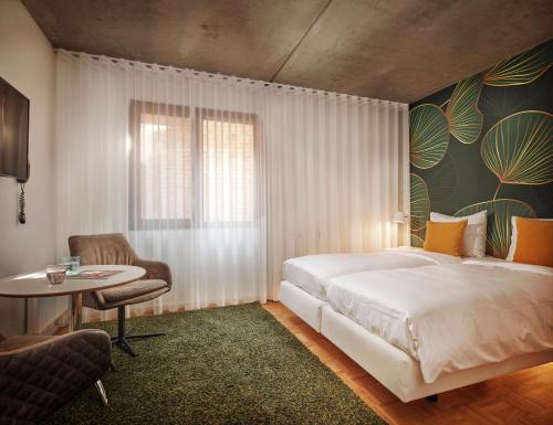 um quarto com uma cama, uma mesa e uma cadeira em BANKS Antwerp em Antuérpia