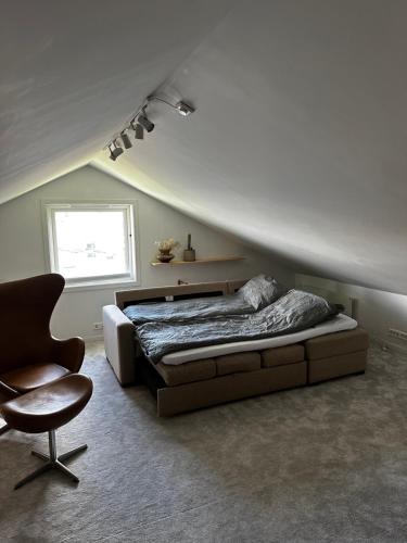 een slaapkamer met een bed, een stoel en een raam bij Lovely home in maritime surroundings near Stavanger in Stavanger