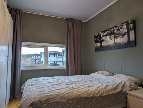 a bedroom with a bed and a window at Green appartement in Sandnes