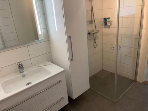 a white bathroom with a shower and a sink at Moderne leilighet fra 2019 in Sandnes