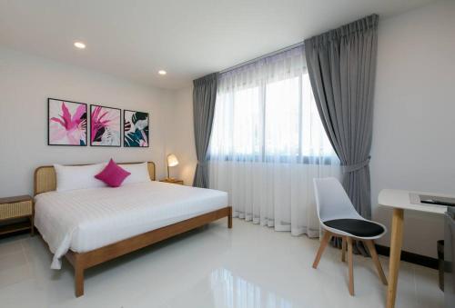 a bedroom with a bed and a desk and a window at Wow Academy & Stay Soi Tai-Aed 3A in Ban Suan