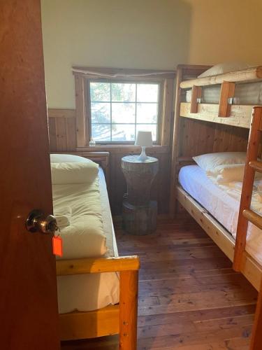 a bedroom with two bunk beds and a window at Rustic Beaverfoot Lodge Room N3 in Parson