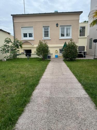 une maison avec un chemin devant elle dans l'établissement Ayline, à Drancy