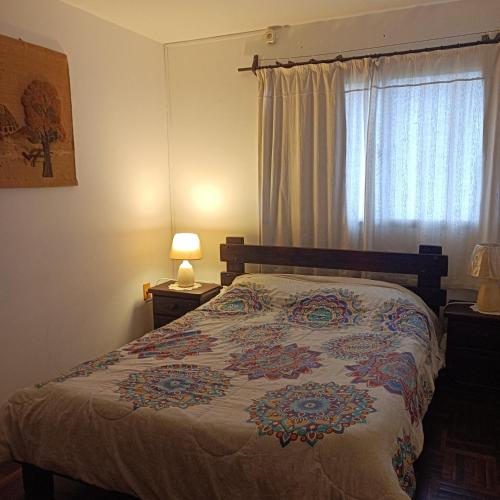 ein Schlafzimmer mit einem Bett und einem Fenster in der Unterkunft Colonia Costanera in Colonia del Sacramento