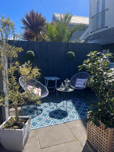 a patio with two tables and chairs and a fence at Ocean Reach in Porthcawl