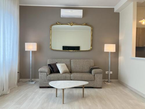 a living room with a couch and a mirror at Top Stay - Lakes, Mountains, Valley & More in Costa Volpino