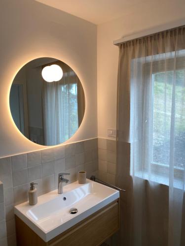 a bathroom with a sink and a mirror at Itt és Most - Szent György-hegy in Raposka