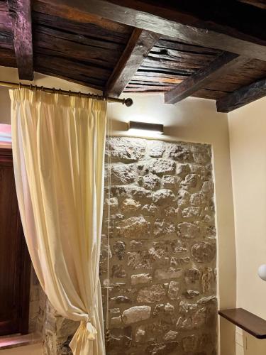 a room with a stone wall and a curtain at AL CARDINALE in Fondi