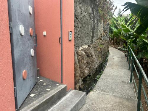 a stairway leading to a building with orange walls at House of the sun in Ponta do Sol