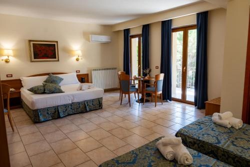 a hotel room with a bed and a table and chairs at Hotel Bisanzio Resort in Rossano