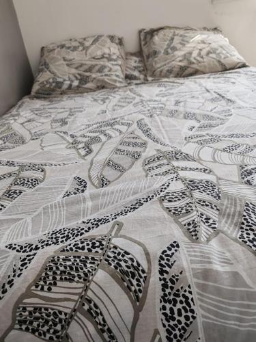 - un lit avec une couette noire et blanche dans l'établissement chambre chez habitant 2, à Carbon-Blanc