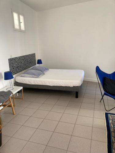 une chambre avec un lit et une chaise dedans dans l'établissement L'Appartement Bleu, à Nice