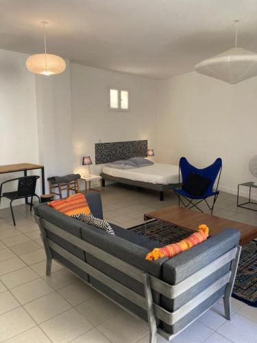 Cette chambre comprend un canapé, un lit et des chaises. dans l'établissement L'Appartement Bleu, à Nice