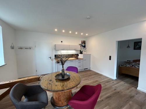 a living room with a table and purple chairs at Pausenhof Zweite-Heimat in Rauhenebrach