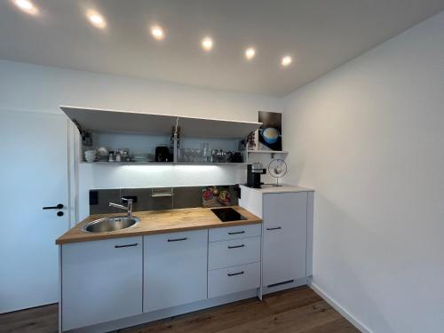 a kitchen with white cabinets and a sink at Pausenhof Zweite-Heimat in Rauhenebrach