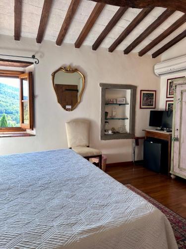 a bedroom with a large bed and a mirror at Casale Le Masse in Greve in Chianti
