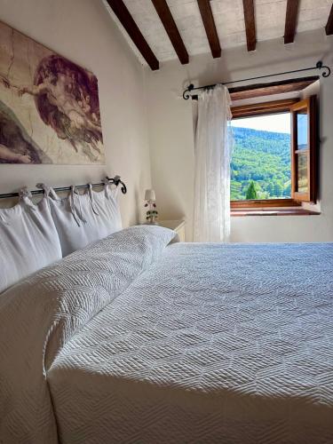 a bedroom with a white bed and a window at Casale Le Masse in Greve in Chianti