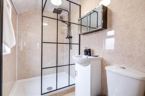 a bathroom with a shower and a toilet and a sink at Cozy Nook-Hot Tub, Sleeps 8, Free Parking, Netflix in Leicester