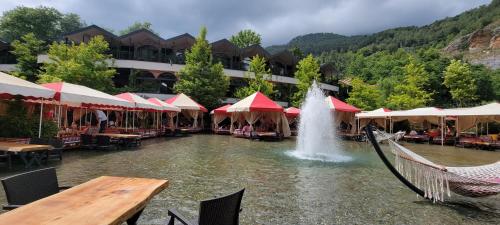 a fountain in a pond in front of a resort at Jasminpark Villa in Alanya