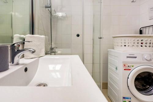 a bathroom with a sink and a washing machine at Ocean Pearl in Peyia