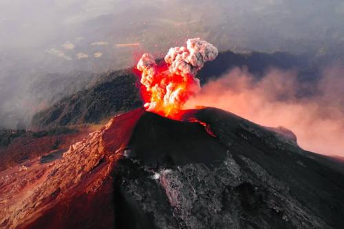 an aerial view of a volcano with fire and smoke at Peaceful Hideaway in Santa Cruz La Laguna