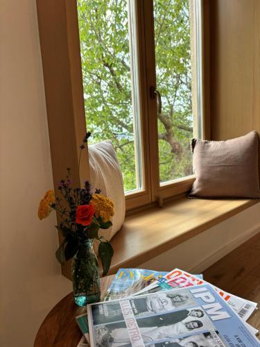 a window with a vase of flowers on a table at Itt és Most - Szent György-hegy in Raposka