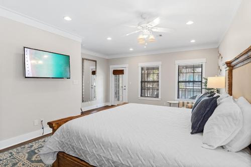 a bedroom with a bed and a tv on the wall at Coastal91 Free Golf Cart Gated Beach Access in Destin
