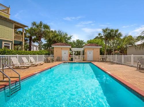 a swimming pool with chairs and a house at Coastal91 Free Golf Cart Gated Beach Access in Destin