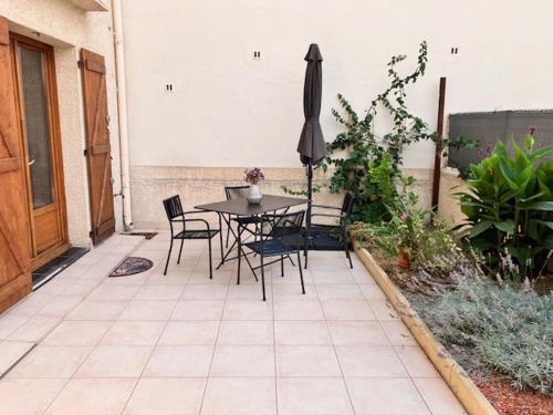 a patio with a table and chairs and an umbrella at T3 - coeur de Port-Vendres RDC Cour in Port-Vendres