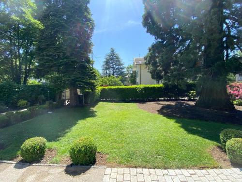 a yard with a large lawn with trees and bushes at Résidence MontBlanc duplex avec jacuzzi in Geneva