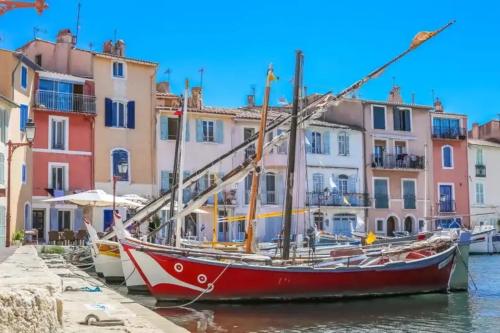 a boat is docked in the water in front of buildings at Un Petit Coin de Provence - Istres - Maison Contemporaine Avec Piscine Privée Chauffée, Entre Plages Et Provence, Borne 11 kW in Istres