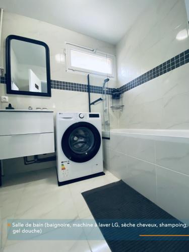 - un lave-linge dans la salle de bains pourvue d'un miroir dans l'établissement Appartement parisien neuf, moderne avec une grande salon, 2 chambres, 4 lits, parking gratuit, 15min de Paris et 13 min aéroport Orly, à Vitry-sur-Seine