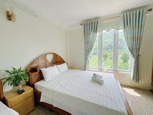 a bedroom with a large bed with a large window at Khách Sạn Gía Rẽ Mai Châu Tiến Loan in Mai Chau