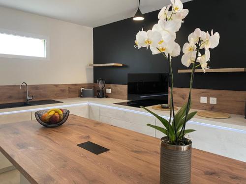 eine Vase mit Blumen auf einem Holztisch in der Küche in der Unterkunft La Clé des Champs Maison familiale à 15min Disneyland Paris WIFI GRATUIT in Boutigny