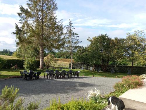 a group of tables and chairs in a park at Gîte du Coudray in Neuillé-Pont-Pierre