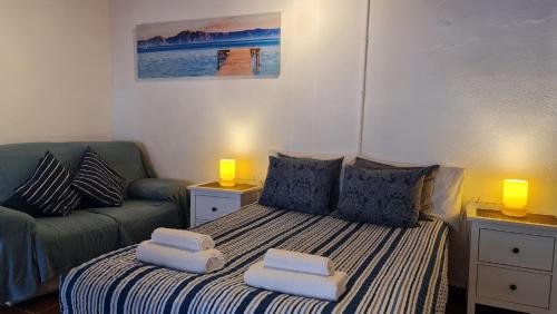 a bedroom with a bed with pillows and a couch at Casa Marcos in La Gomera with relaxing terrace in Agulo