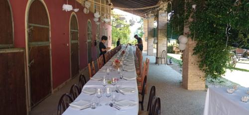 a long row of tables with plates and wine glasses at La Regina del Bosco in Rivignano