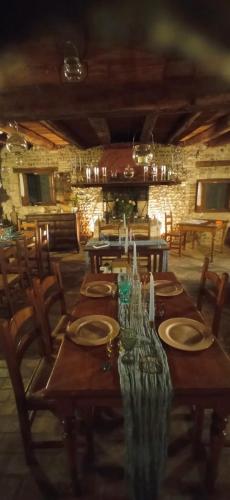 a long wooden table with plates and candles on it at La Regina del Bosco in Rivignano