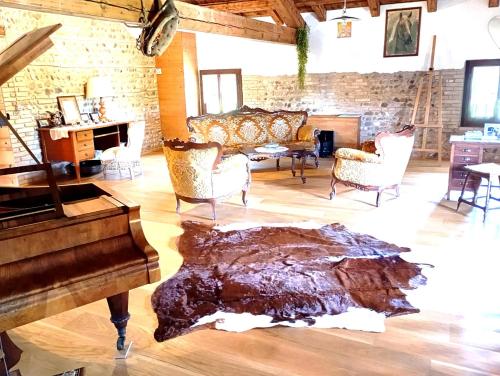 a large living room with a piano and chairs at La Regina del Bosco in Rivignano