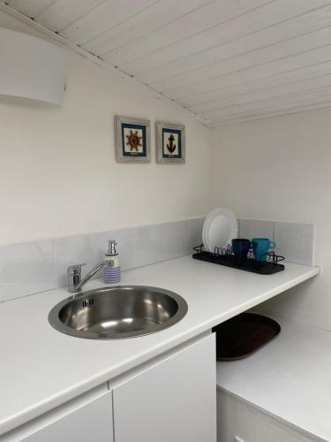 Un baño con lavabo y encimera blanca. en Delizioso Monolocale mansardato, en Viareggio