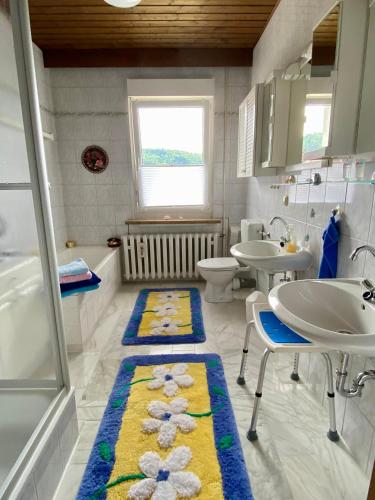 a bathroom with a sink and two sinks and a tub at Regenbergblick in Zella-Mehlis