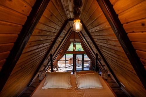 a bed in a small room with a window at Cabana VP in Alunişu