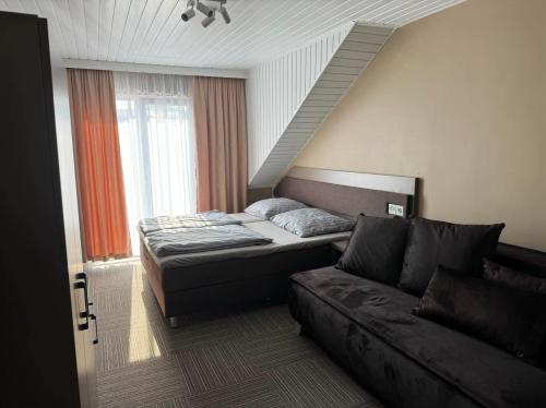 a bedroom with a bed and a couch at Costa Mielno in Mielno