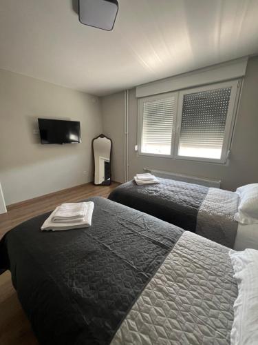 a hotel room with two beds and a flat screen tv at Bella Mela in Tuzla