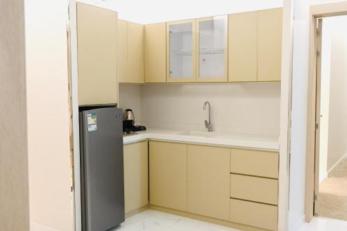 a kitchen with a refrigerator and a sink at شقق مشراق هوم للأجنحة الفندقية in Huḑayb